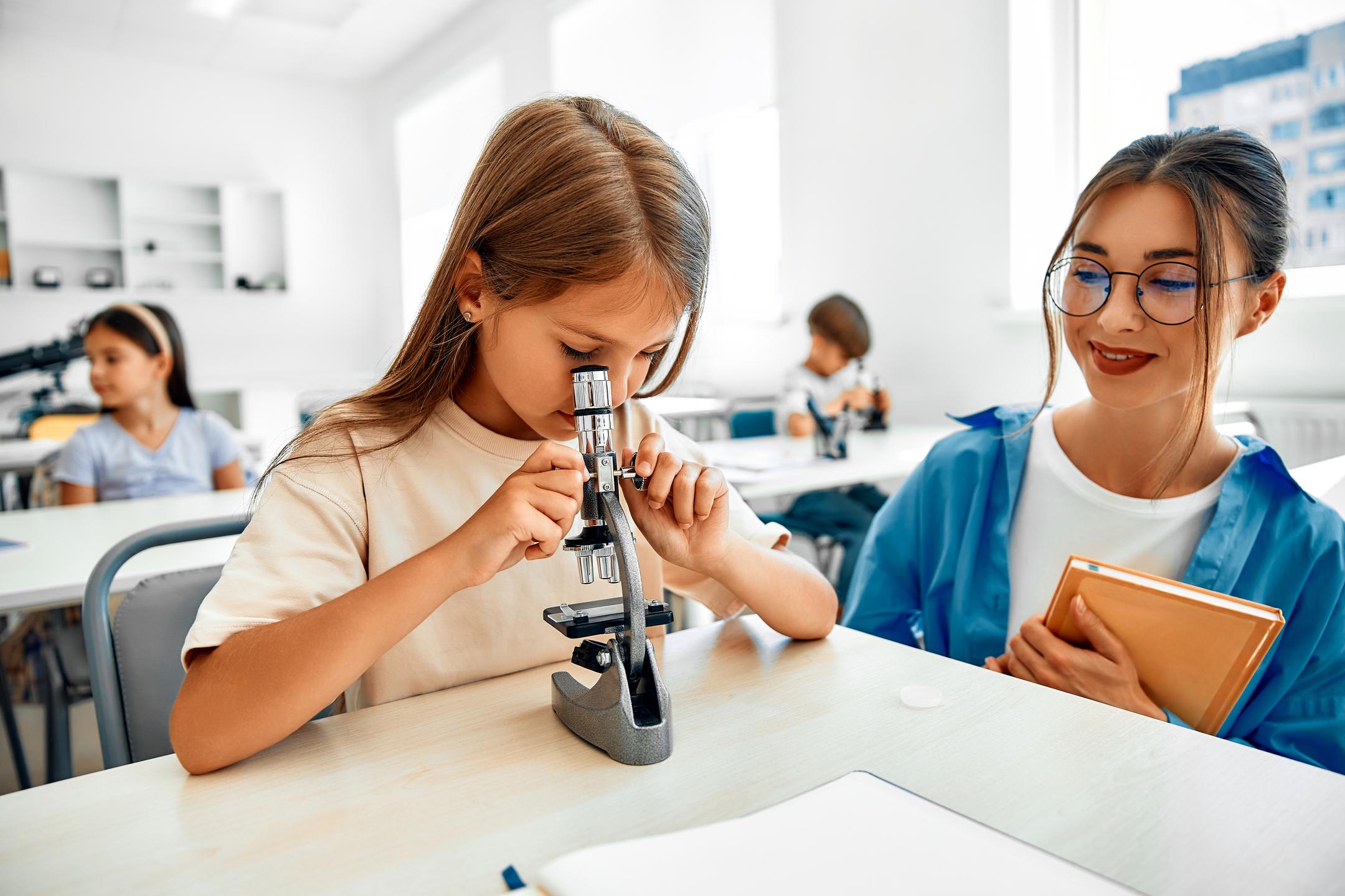 A girl using a microscope for scientific exploration, demonstrating curiosity and engagement in a learning environment.