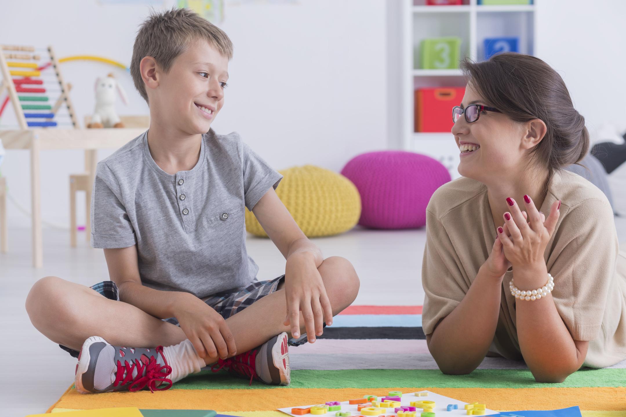 A happy child interacting with a school counsellor, reflecting a positive and supportive educational environment.