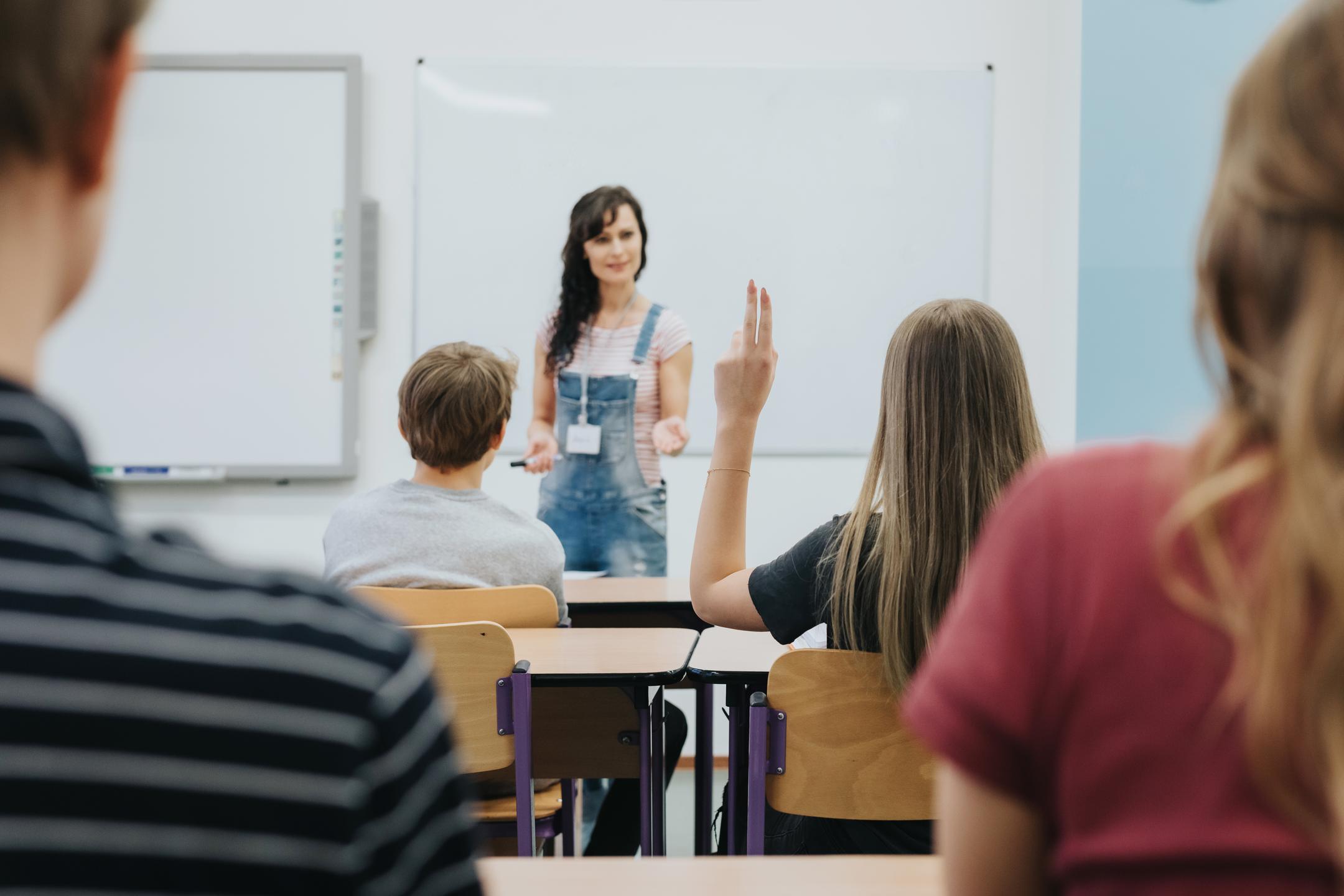 A teacher standing in front of a classroom full of students, ready to lead a lesson.