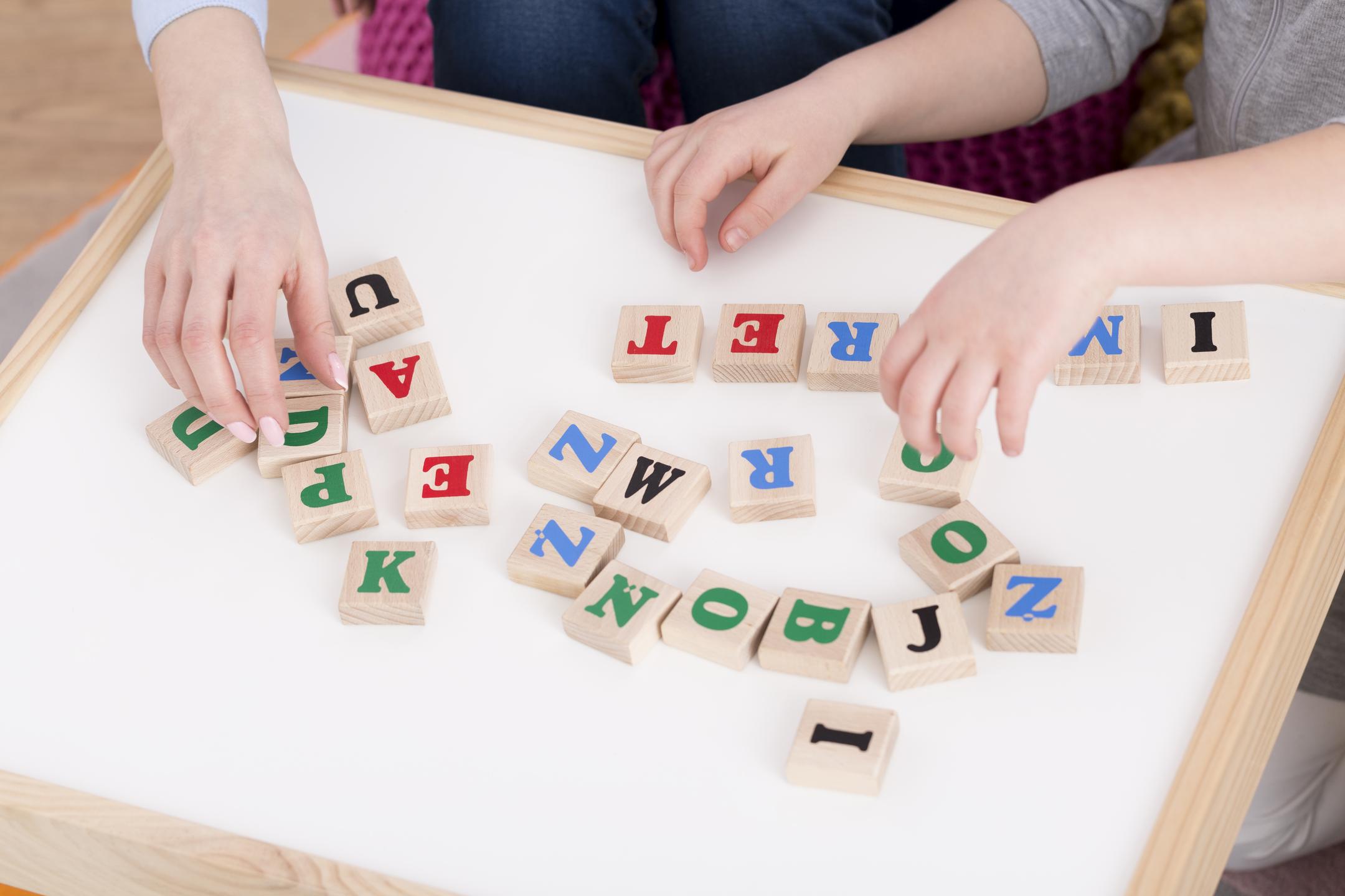 Colorful wooden blocks with letters on them, arranged to support learning and literacy development in a playful, educational setting.