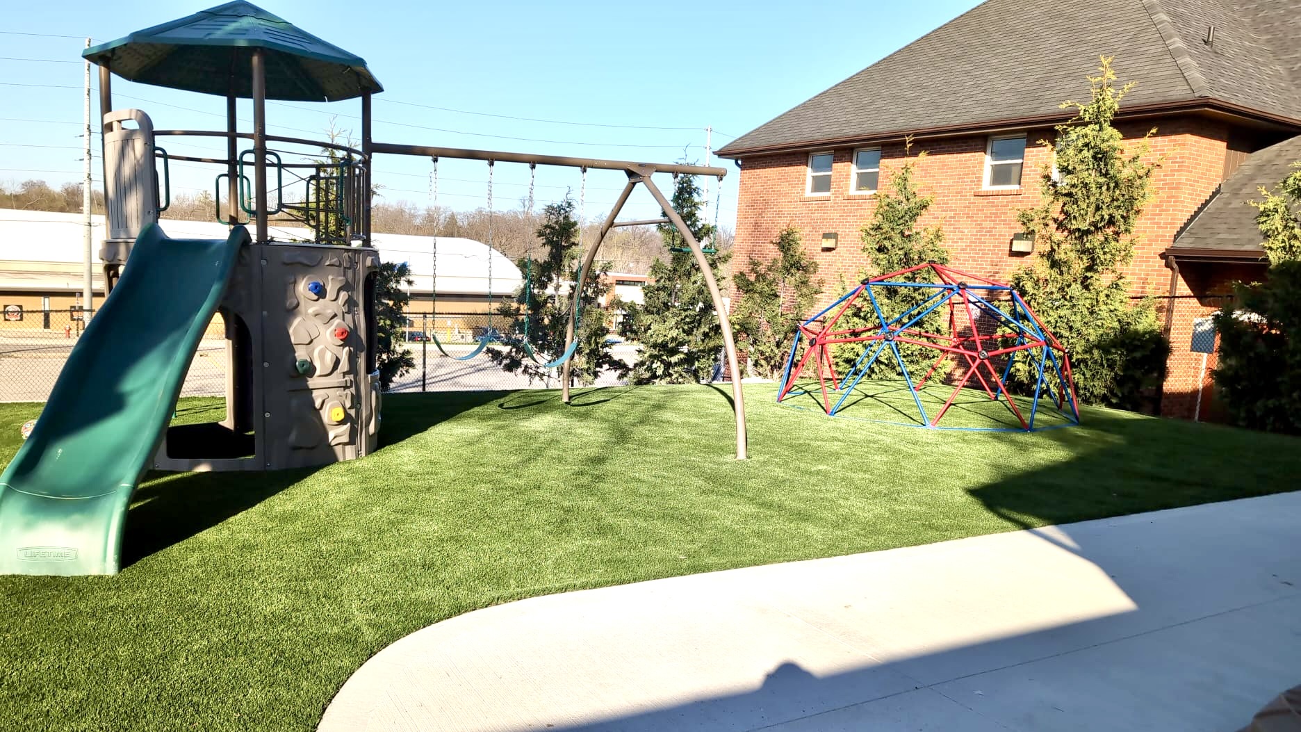 A child's playground in a grassy yard.