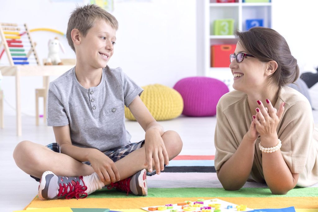 A happy child interacting with a school counsellor, reflecting a positive and supportive educational environment.